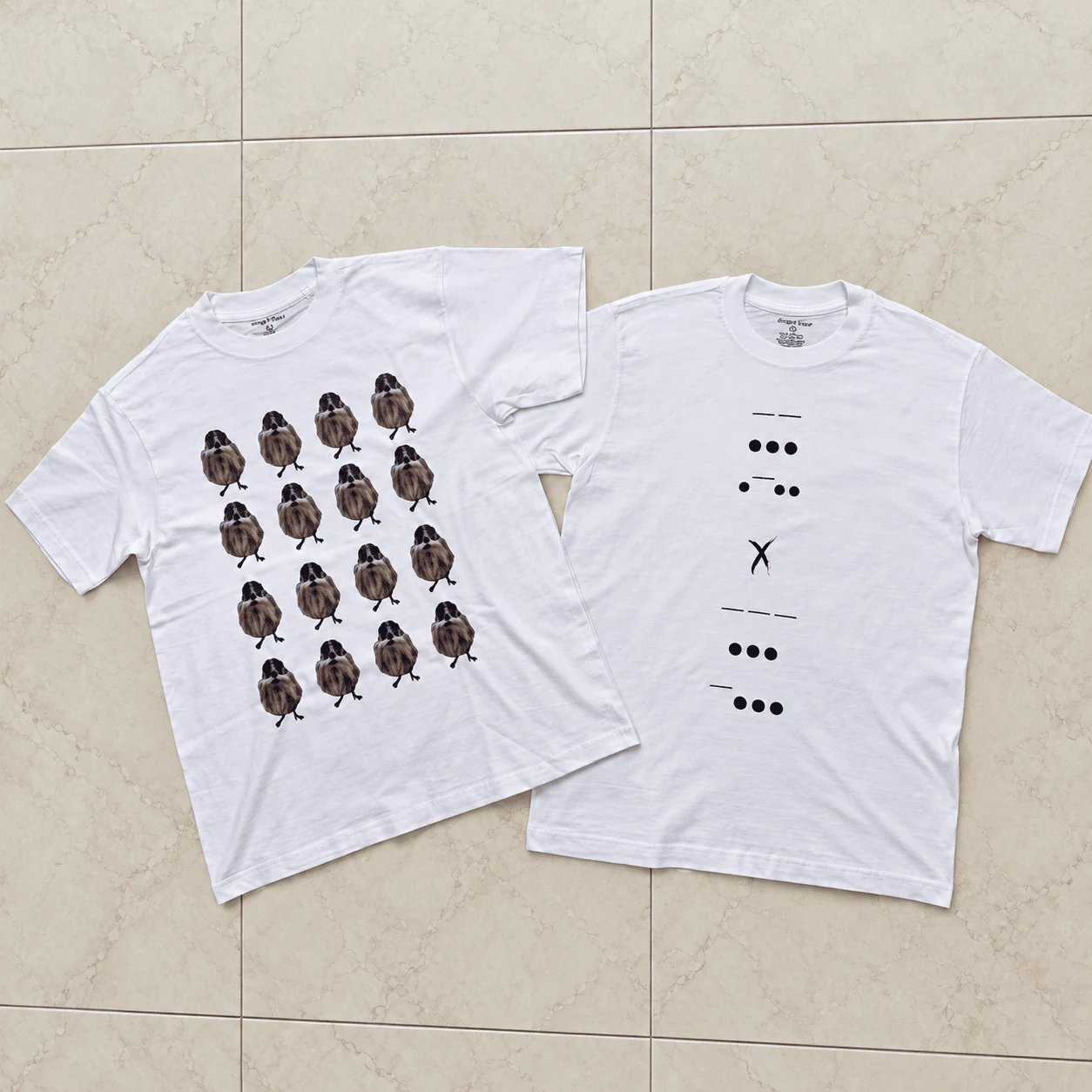 Custom oversized white t-shirts flat lay with illustrated bird pattern and morse code typography
