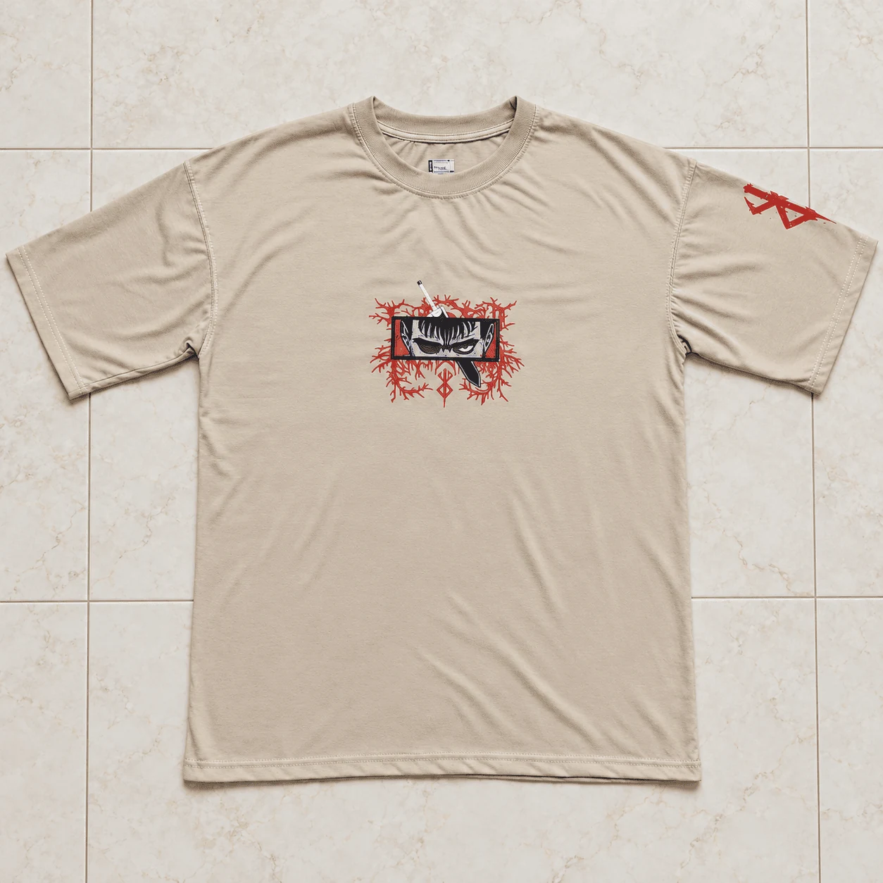 Sand beige drop shoulder oversized tee with Berserk cursed eye chest print and sleeve brand