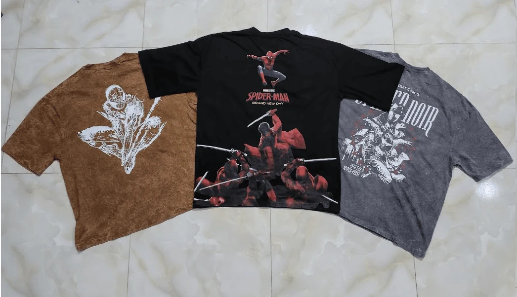 Spider-Man graphic tees fan layout across grey acid wash, black, and mocha brown colorways