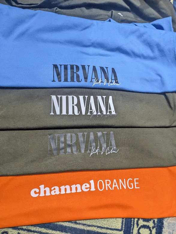 Folded colorway stack of Nirvana and Channel Orange streetwear tees